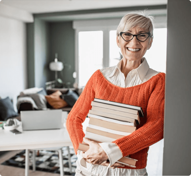 smiling older teacher woman holding books